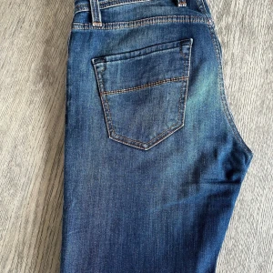 Blå jeans från Sartoria Tramarossa - Snygga blå jeans från Sartoria Tramarossa med knappgylf, helt nya och endast testade. Passar bra till både vardag och mer uppklädda tillfällen.