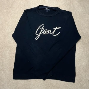 Gant - Tröja - Snygg mörkblå tröja från Gant med vit logotyp på bröstet. Tröjan har långa ärmar och ribbade muddar vid ärmslut och nederkant. Perfekt för en stilren look. Vid minsta fråga eller fundering hör av er🤝