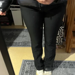 Svarta byxor - Snygga svarta bootcut byxor som passar perfekt till både vardag och fest. De har en klassisk design med en tight passform upptill och utsvängda ben. Perfekta för att skapa en stilren look.