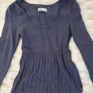 Blå babydoll Hollister - Säljer en snygg blå stickad babydoll tröja från Hollister. Tröjan har långa ärmar och ett ribbat mönster nedtill som ger en fin form. Storlek S! 🌸💐