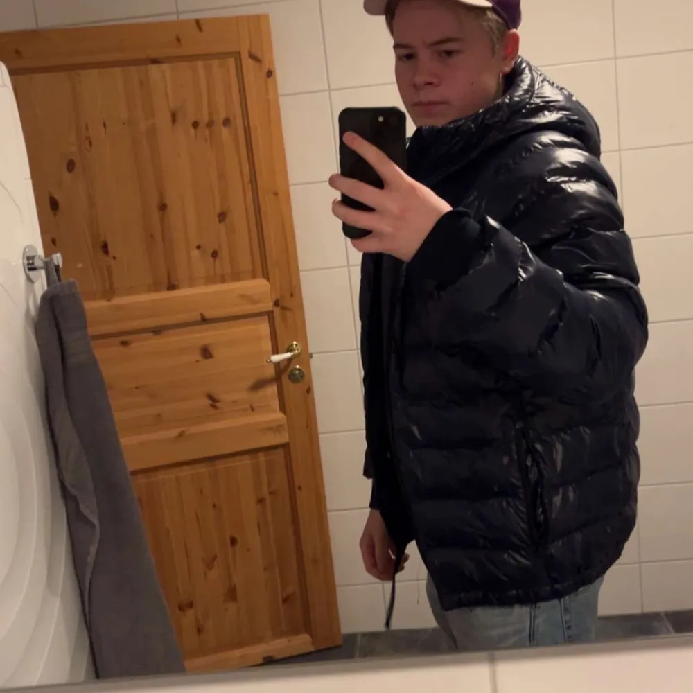 Snygg svart pufferjacka från Peak Performance med huva och dragkedja. Perfekt för kyliga dagar med sin vadderade design. Jackan är i topp skick inga skador, hör av er vid frågor och funderingar😁. Takit.