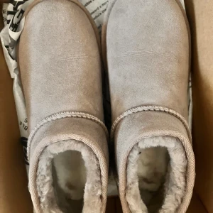 Beige uggs äkta - Säljer ett par mysiga beige boots från UGG med mjukt foder och rund tå. Perfekta för kalla dagar med sin varma insida och robusta sula.