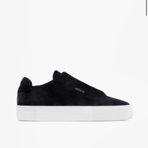 Svarta sneakers från Axel Arigato - Stilrena svarta sneakers från Axel Arigato. Skorna har en vit sula och är tillverkade i mocka. Perfekta för en modern och avslappnad look. Köpte dem för 2550kr men säljer de för 1200, har använt de men de ser bra ut fortfarande. Kom privat för personliga bilder. 