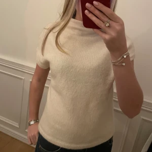Vit kortärmad tröja - Säljer en stilren vit tröja med korta ärmar. Perfekt för en enkel och elegant look. Har tagit bort lappen i ryggen då den syntes igenom. Ursprungligen 299