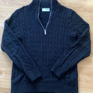 Stickad halfzip Selected Homme - Snygg svart stickad tröja från Selected Homme med kabelstickat mönster och dragkedja framtill. Perfekt för kyliga dagar med sin höga krage och långa ärmar. Ett stilrent val för garderoben.använd max 3ggr skick 9/10 inga defekter skitsnygg