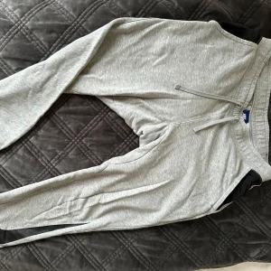 Grå mjukisbyxor från Nike - Säljer ett par grå mjukisbyxor från Nike med snörning i midjan. Fickor på sidorna och en bak med en dold knapp. 