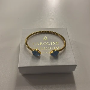 Guldarmband från Caroline Svedbom - guldarmband från Caroline Svedbom men ljusa klarblå stenar, armbandet har ett fint skick och ser nästintill oanvänt ut nypriset är 795kr