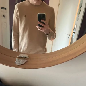 Beige tröja från Ralph Lauren - Säljer en stilren beige tröja från Ralph Lauren i mjuk Pima bomull. Tröjan har en klassisk rund hals och långa ärmar. Perfekt för en avslappnad och elegant look. 🧥