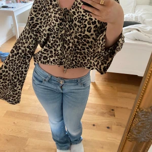 Leopardmönstrad blus  - Trendig leopardmönstrad blus med knytning framtill. Blusen har vida ärmar och en croppad passform. Använt en gång!