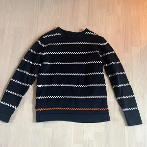 Randig tröja från Selected Homme - Snygg randig tröja från Selected Homme i mörkblått med vita och orange detaljer. Tröjan har långa ärmar och en rund halsringning. Perfekt för en stilren look.