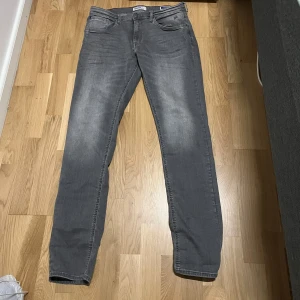 Grå jeans från Blend - Snygga grå jeans från Blend med en klassisk straight passform. De har en diskret tvättad look och är tillverkade i ett bekvämt material. Perfekta för en stilren vardagslook. Använt 2 gånger och säljer pågrund att de är för långa för mig. Jag är 178. 