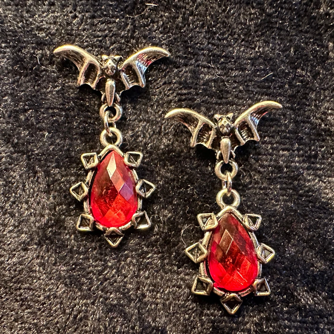 Gothiska örhängen med fladdermus och blodröd sten