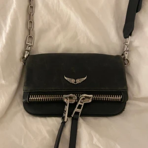 Zadig & Voltaire väska - Väska från zadig & voltaire. Köpt på plick så har inte orginal kvittot. Tror att den är äkta då den är i bra kvalitet och bra material. Ser ut som en äkta. Köpt på plick för 1.400kr.