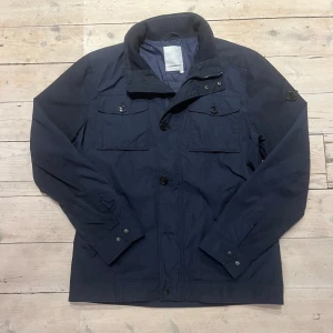 J.Lindeberg field jacket - Riktigt snygg och trendig field jacka från J.Lindeberg. Den har inte några defekter och är nästintill perfekt skick.                                              Skick: 9,5/10. Nypris:  3-4000kr