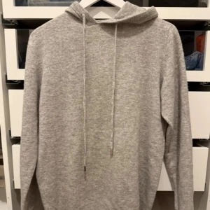 Helt ny Kashmir hoodie - Säljer en stilren grå Kashmir hoodie och långa ärmar. Perfekt för en avslappnad look. Den är mjuk och bekväm, idealisk för kyligare dagar. Helt ny endast testad passar 170 hör av er vid frågor eller funderingar kan gå ner i pris 