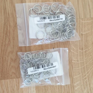 Silverfärgade nyckelringar i två storlekar - Säljer två påsar med silverfärgade nyckelringar. En påse innehåller ca 40-50 ringar med 15 mm diameter och den andra ca 40-50 ringar med 12 mm diameter. Perfekta för smyckestillverkning eller andra kreativa projekt.