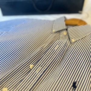 Ralph lauren skjorta - Riktigt snygga och trendig raffe skjorta i toppskick 9,5/10. Riktigt härlig blå randig färg perfekt till våren. Passar slimfit. Nypris: 1899. Svår storlek att få tag på. Priset ej hugget i sten vid smidig affär, passa på. Kvitto från Zalando ingår. Bara att höra av sig vid frågor// Carl 
