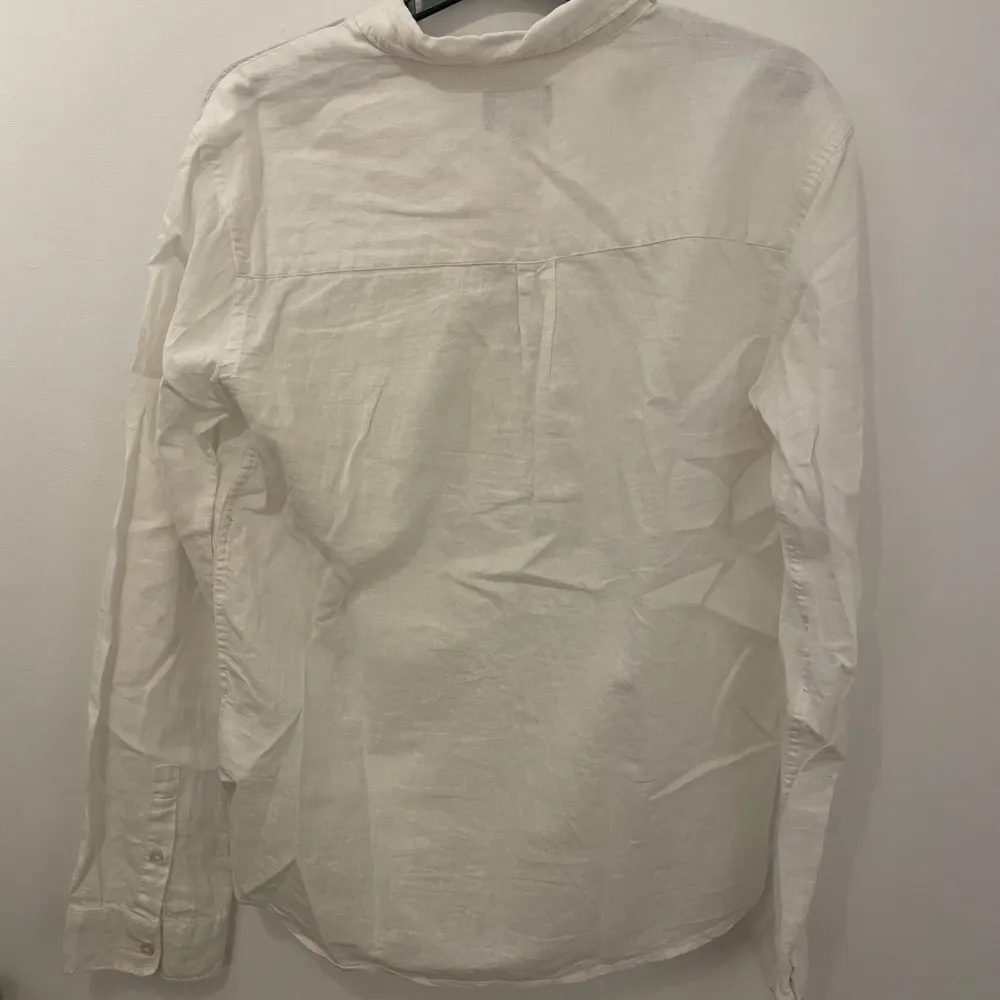 Säljer en stilren vit skjorta från Lyle & Scott med lång ärm och klassisk krage. Skjortan har en broderad logga på bröstfickan och knappar framtill. Perfekt för en snygg och avslappnad look. Skriv om ni har några funderingar och priset är inte hugget i sten!. Paidat.
