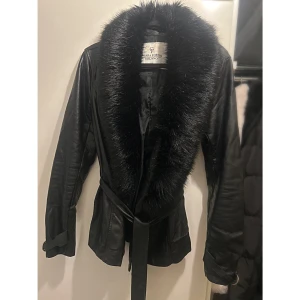 Chiara Forthi - PU läderjacka, faux fur, strl 34 - Snygg svart jacka med pälskrage, kragen är löstagbar och det saknas 2 knappar som ska sitta på jackan för att fästa den i. Bälte i midjan. 