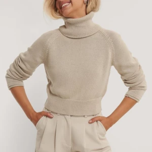 Beige stickad polotröja - Säljer en beige stickad polotröja med långa ärmar. Tröjan har en ribbad polokrage och ribbade muddar vid ärmslut och nederkant. 