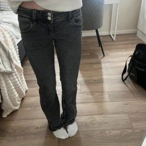 Svarta jeans från Gina Tricot - Snygga low Waits svarta jeans från Gina Tricot i storlek 152. Ganska mörk grå färg. De är upp sprättade där nere eftersom byxorna är korta på mig som är 159. 