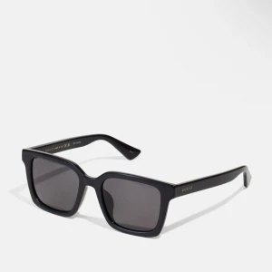 Svarta solglasögon från Gucci - Snygga svarta solglasögon från Gucci med en fyrkantig form. De har en elegant design med mörka linser och subtila gulddetaljer på skalmarna. Perfekta för en stilren look. Dom är helt oandvända säljer för att dom var för stora för mitt ansikte 