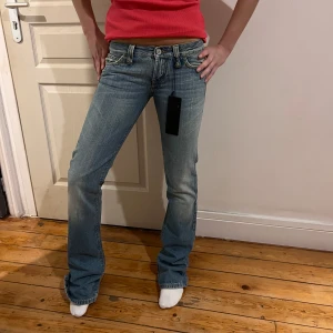 Blå jeans med bootcut lågmidjade  - Snygga blå jeans med bootcut och låg midja. De har en klassisk femficksdesign och en dragkedja med knapp framtill. Perfekta för en avslappnad stil.