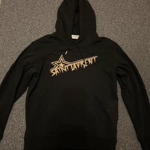 Saint Laurent hoodie - Tja! Säljer denna tvärfeta saint Laurent hoodie i strl M. Hoodien är i utmärkt skick, finns inga skador eller defekter, dessutom försiktigt använd. Hoodien är svart och självklart äkta. Hör av er vid frågor eller funderingar! 