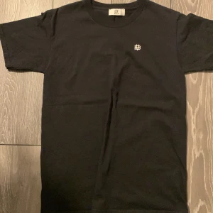 Svart need money for Porsche -shirt från Bvaldi - Snygg svart t-shirt från Bvaldi med ett litet vitt tryck fram och texten 'Need Money for Porsche' i vitt på baksidan. Perfekt för en avslappnad stil.