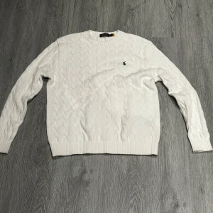 Ralph Lauren sweatshirt  - Säljer en stilren vit stickad tröja från Ralph lauren en riktig trendig tröja. Skick 9,5 av 10 och tveka inte på att höra av er. Påse kommer med på köpet