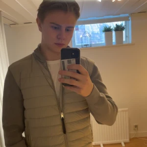 Grå quiltad väst från Woolrich - Säljer en snygg grå quiltad cardigan från Woolrich. Den har inga defekter alls och är i mycket bra skick. Västen är i storlek herr XL och har en mindre passform som passar M/L. Jag är 185cm och sitter bra på mig.  Nypris ligger på 4000kr och är helt slutsåld. Mvh Jeppe 