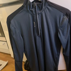 Mörkblå tröja från Abacus - Säljer en mörkblå tröja från Abacus med dragkedja vid halsen. Tröjan har långa ärmar och är perfekt för kyligare dagar. Den är tillverkad i ett syntetmaterial som ger en skön passform. (Obs: Vet ej storleks nr, står S men passar även M)