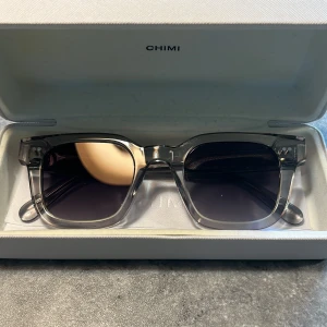 Chimi  - Chimi 04 grey.                                         Storlek: passar alla.  Skick: 10/10 helt nya. Nypris: 1350kr  Tillbehör: Solglasögonen, original fodral samt duken. Hör av er för ev frågor och bilder. Köpta i NK Göteborg Priset kan diskuteras vid snabb affär!📋