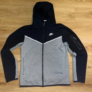 Grå och svart nike tech fleece - Säljer en snygg grå och svart nike tech fleece typ helt ny använd några gånger är samt en äldre som inte säljs längre pris kan diskuteras passformen är lite stor känns mer som en M 