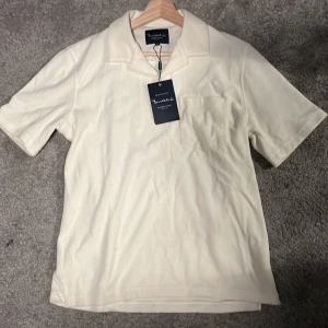 Vit kortärmad skjorta från Bondelid - Säljer en stilren vit kortärmad skjorta från Bondelid. Skjortan har en klassisk krage och en bröstficka. Perfekt för en avslappnad och snygg look. Har använt den en gång bara och fick den i födelsedags present men den var för stor skick är 10/10 och en ny går för cirka 800