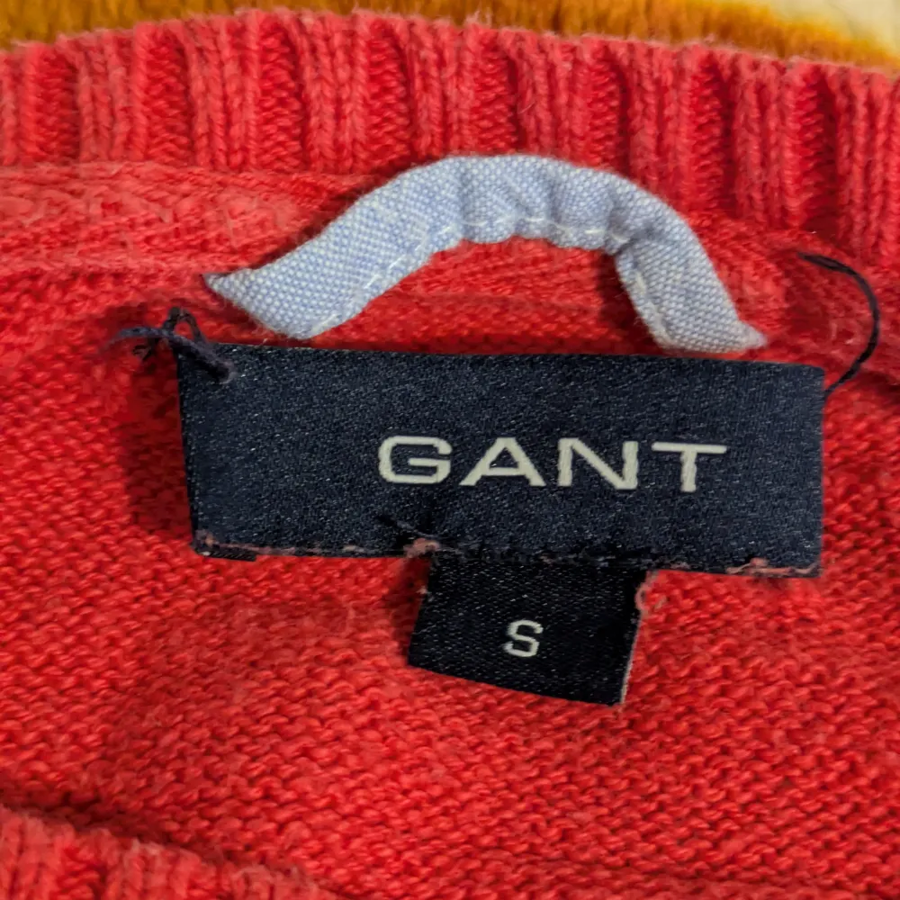 Säljer en snygg röd tröja från GANT i 100% bomull. Tröjan har en broderad logotyp på bröstet och ribbstickade muddar vid ärmslut och nederkant. Perfekt för en stilren look!. Neuletakit & Villapaidat.