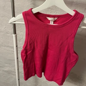 Rosa ribbad topp - Snygg rosa ribbad topp från H&M. Perfekt för varma dagar med sin ärmlösa design och croppade längd. Enkel och stilren, passar till många olika outfits.