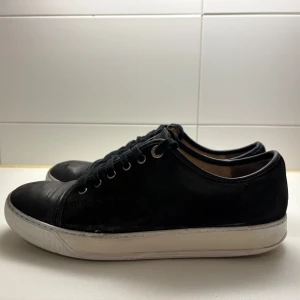 Svarta sneakers från Lanvin - Svarta lanvins cap toe som har blivit försmå, de ser som nya ut💯innersulan är i använt skick men de tänker man inte på! Storlek uk8 som motsvarar 42 men passar 43 också 