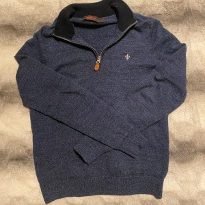 Morris zip 100% merinoull  - Säljer en stilren blå tröja i 100% merinoull från Morris. Tröjan har en dragkedja vid halsen och en liten broderad detalj på bröstet. Perfekt nu inför den milda tiderna. Helt perfekt kondition.
