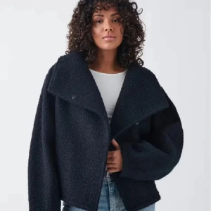 teddyjacka - Mysig svart teddyjacka med en oversized passform och stora slag. Perfekt för kyliga dagar med sin fluffiga textur och stilrena look. Jackan har långa ärmar och en enkel design som gör den lätt att matcha med olika outfits.