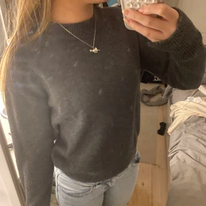 Mörkgrå stickad tröja från H&M - Säljer en s mörkgrå stickad tröja från H&M. Tröjan har slits vid ärmarna. Perfekt för kyligare dagar och lätt att matcha med olika outfits. Hör av dig vid intresse! 🖤