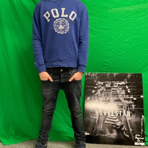 Polo hoodie - Säljer en snygg blå hoodie från Polo med stort tryck på framsidan. Tröjan har långa ärmar och en klassisk passform. Perfekt för en avslappnad stil. 