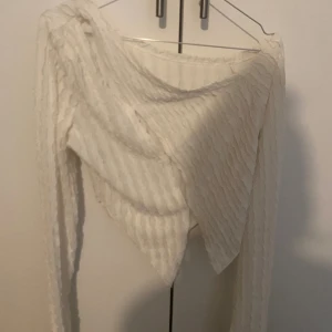 Vit ribbad tröja - Säljer en superfin vit ribbad tröja med långärmad design. Perfekt för både vardag och fest! Den har en unik struktur som ger en extra touch till din outfit. Passar perfekt till höst och vinter. öppen på framsidan.