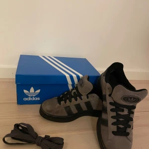 Adidas campus 00s  - Tjena! Säljer mina Adidas campus 00s då jag använt dem Max 3 gånger. Dock är dem lite smutsiga och lite mocka är borta i fronten på vänster sko, se bild 3.Smutset går att tvätta bort. Därför kanonpris👍Nypris 1349 kr. Pris kan diskuteras. Orginalbox 👍