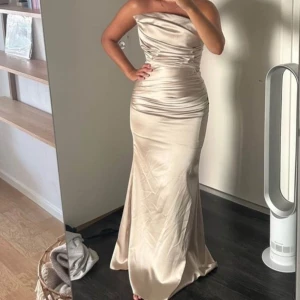 Balklänning beige - Säljer min fina klänning i fint material, silkeliknande. Använt skick men mycket mer att ge! Behöver tvättas. Jag är 1,60 och använder ca 10 cm höga klack utan att fötterna syns. Köpt för 4000kr men säljer för 1100 pga använd.