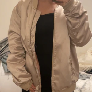 Beige bomberjacka  - Snygg beige/rosa bomberjacka som är i gott skick och endast använd ett par gånger. 