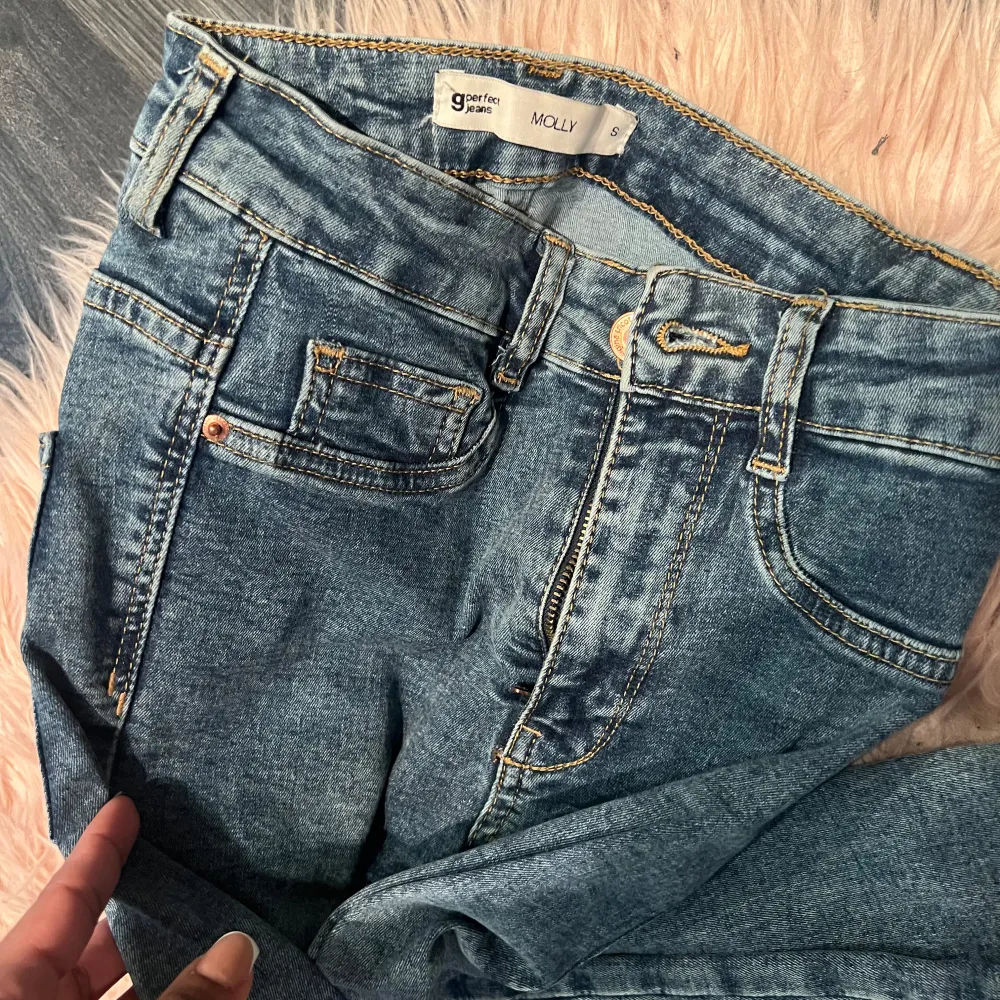 Säljer ett par snygga blå jeans från gina tricot modell molly. De har en klassisk femficksdesign och är gjorda i ett slitstarkt denimtyg. Jeansen har en fransig kant vid bensluten för en trendig look. Perfekta för vardagsbruk och kan enkelt matchas med olika toppar.. Jeans & Byxor.