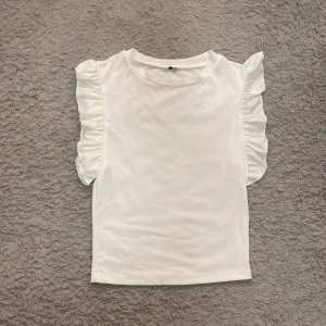 Volang topp - Säljer denna söta volangtopp för ett billigt pris eftersom jag har två. Är i storlek XS och har stretchigt material! 