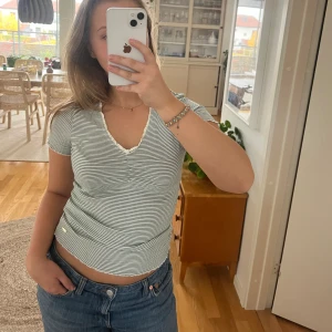 Randig t-shirt - Så fin grön, randig tröja från Lindex. Den är även ribbad. Storlek S. Endast använd ett fåtal gånger så i väldigt bra skick.