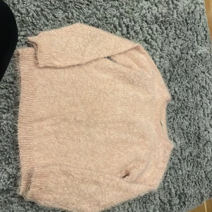 Ljusrosa fluffig tröja från Dreams - Supermjuk och fluffig ljusrosa tröja från Dreams. Perfekt för kyliga dagar med sin mysiga känsla. Tröjan har långa ärmar och en normal passform. Den är gjord i ett stickat material som känns både lyxigt och bekvämt. Passar perfekt till både vardag och mysiga hemmakvällar. 💖